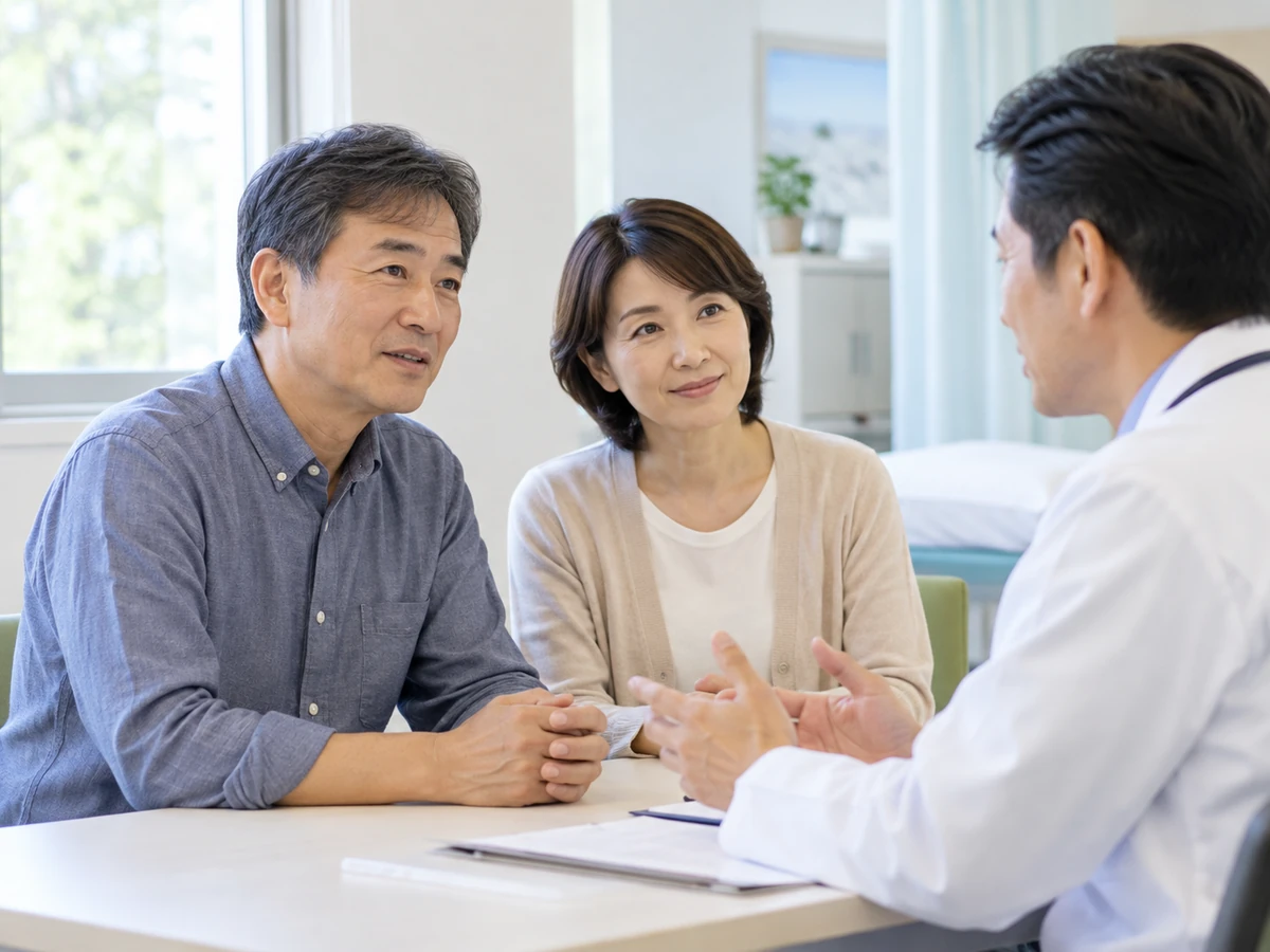 医師と向き合い、今後について話し合う男性と家族。