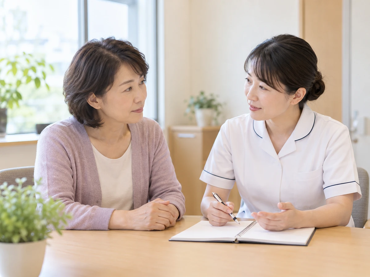 看護師と女性がノートを前にして落ち着いて相談している。