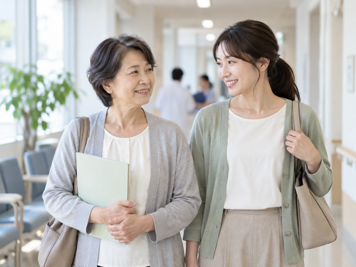書類を持ち病院の廊下を家族と歩く女性