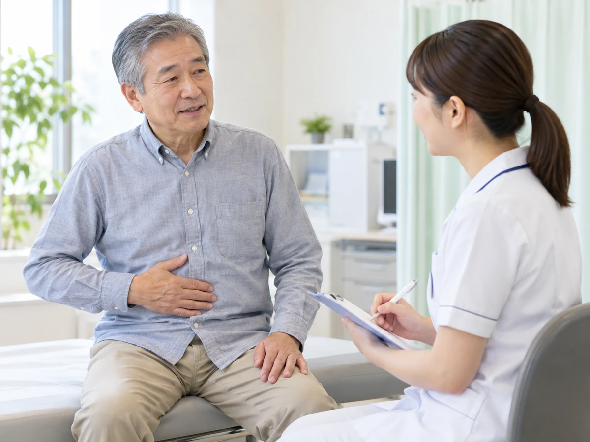 腹部の違和感について看護師に相談する高齢男性