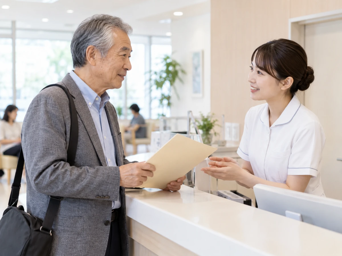 病院の受付でスタッフと話す男性