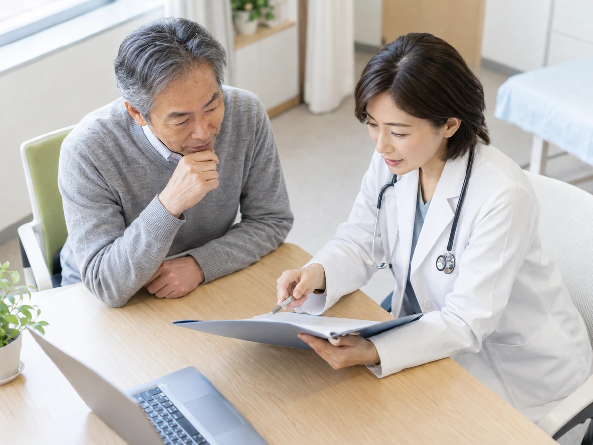 医師と一緒に検査資料を確認する男性の写真