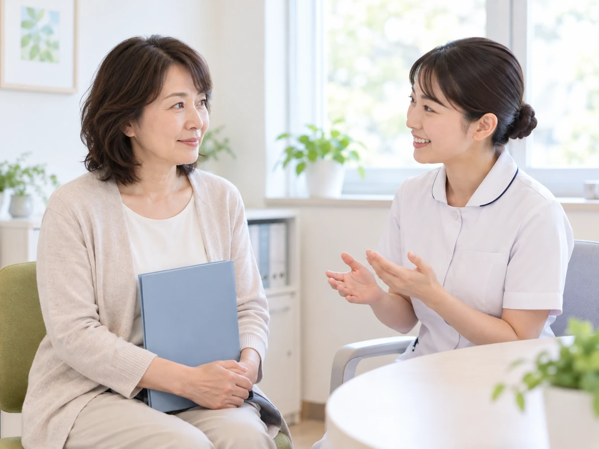 資料を手元に置き、看護師から検査の説明を受ける女性