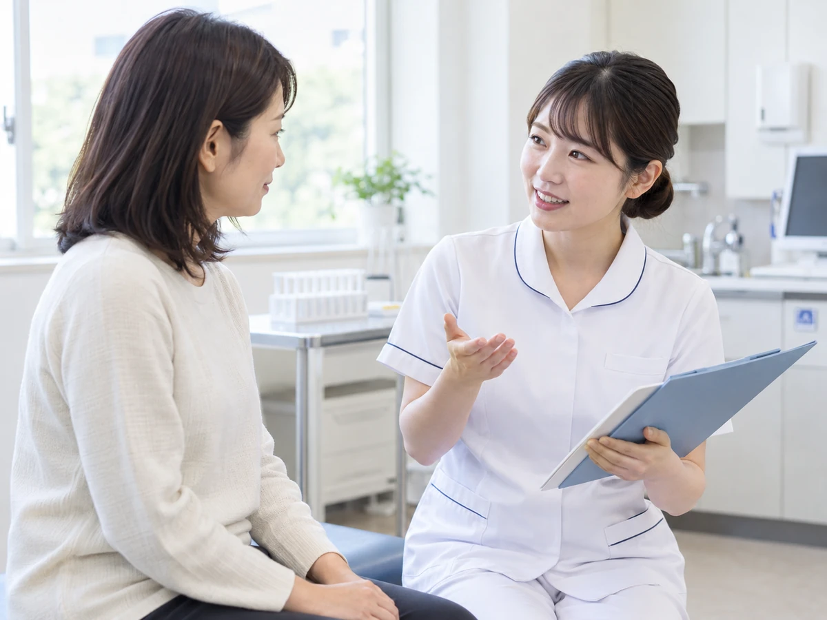 検査室で看護師から説明を受ける女性の写真
