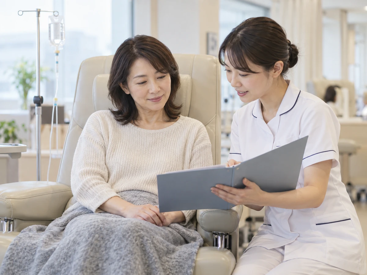 外来の治療用チェアで、女性が看護師から説明を受けている。