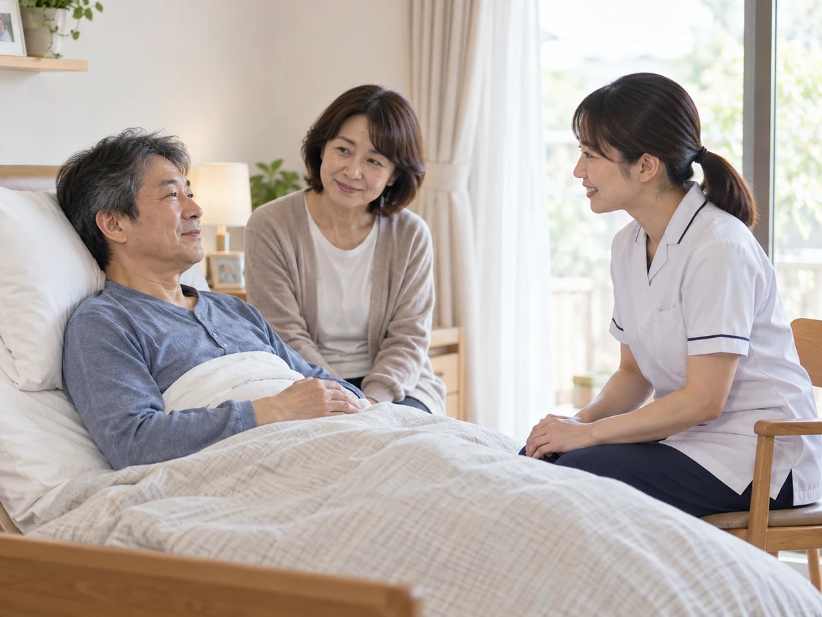 自宅のベッドで上体を起こす男性と家族が、訪問した看護師に話を聞く様子