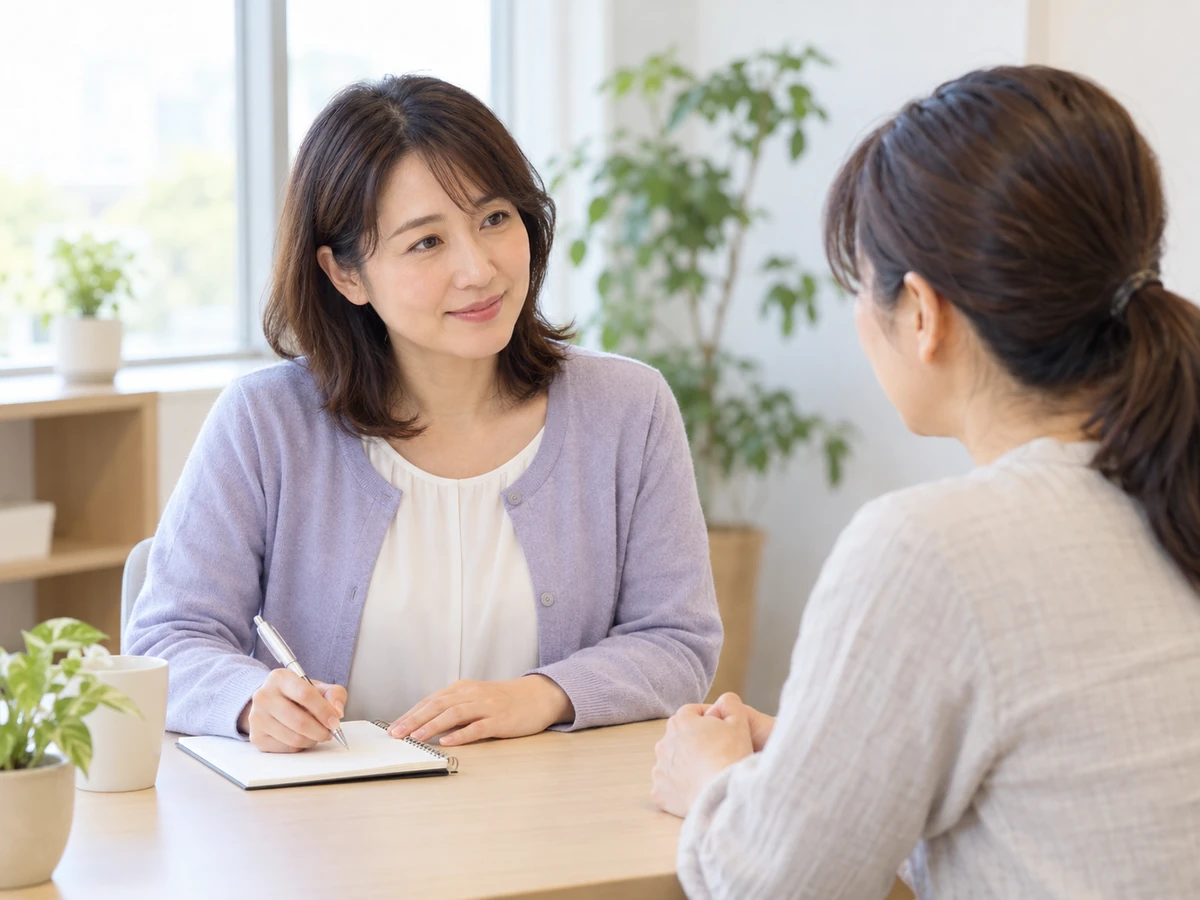 落ち着いた相談室で私服の相談員と話す女性の写真