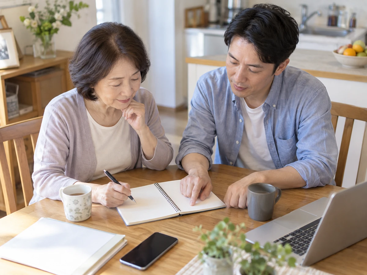 自宅で息子とともに質問をノートへ書き出す女性