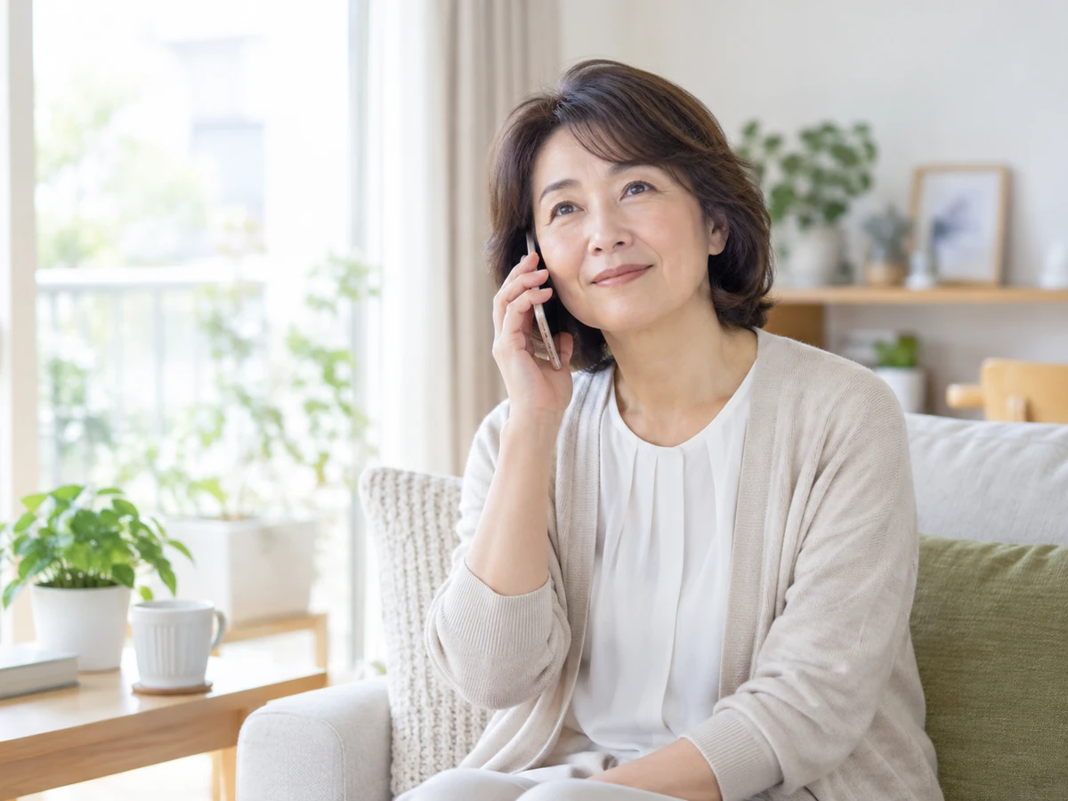 自宅で電話相談をする女性の写真