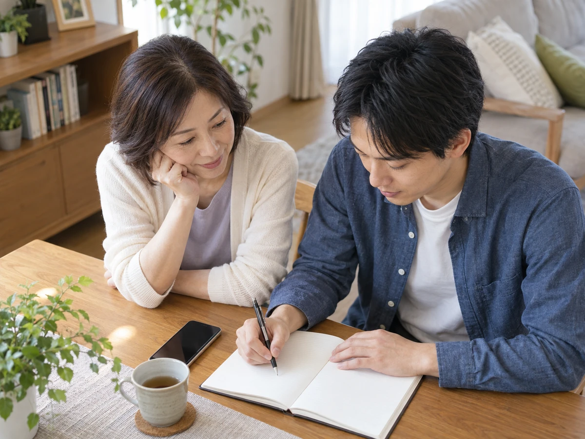 母親と息子がテーブルで相談したい質問をノートにまとめているイメージ