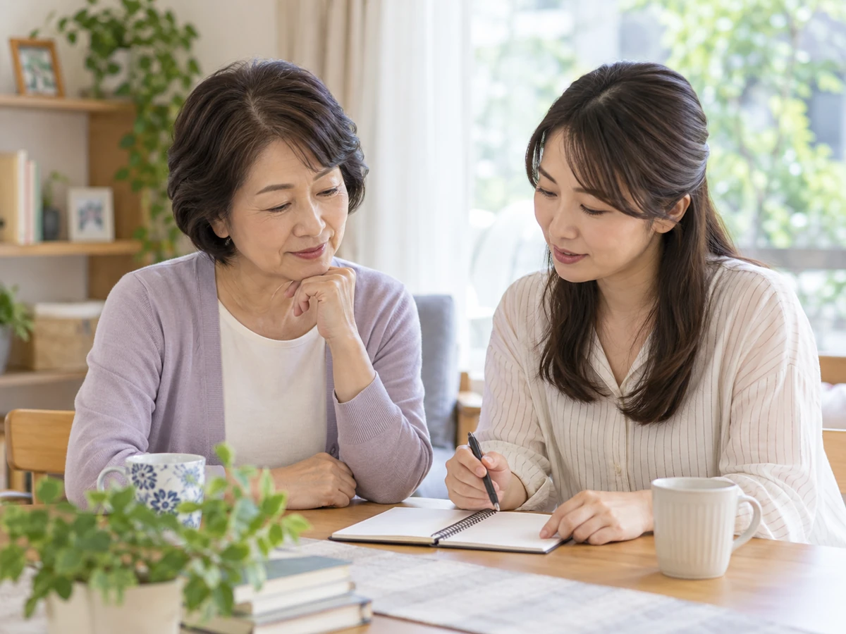 受診時に聞きたいことを家族とノートにまとめる女性