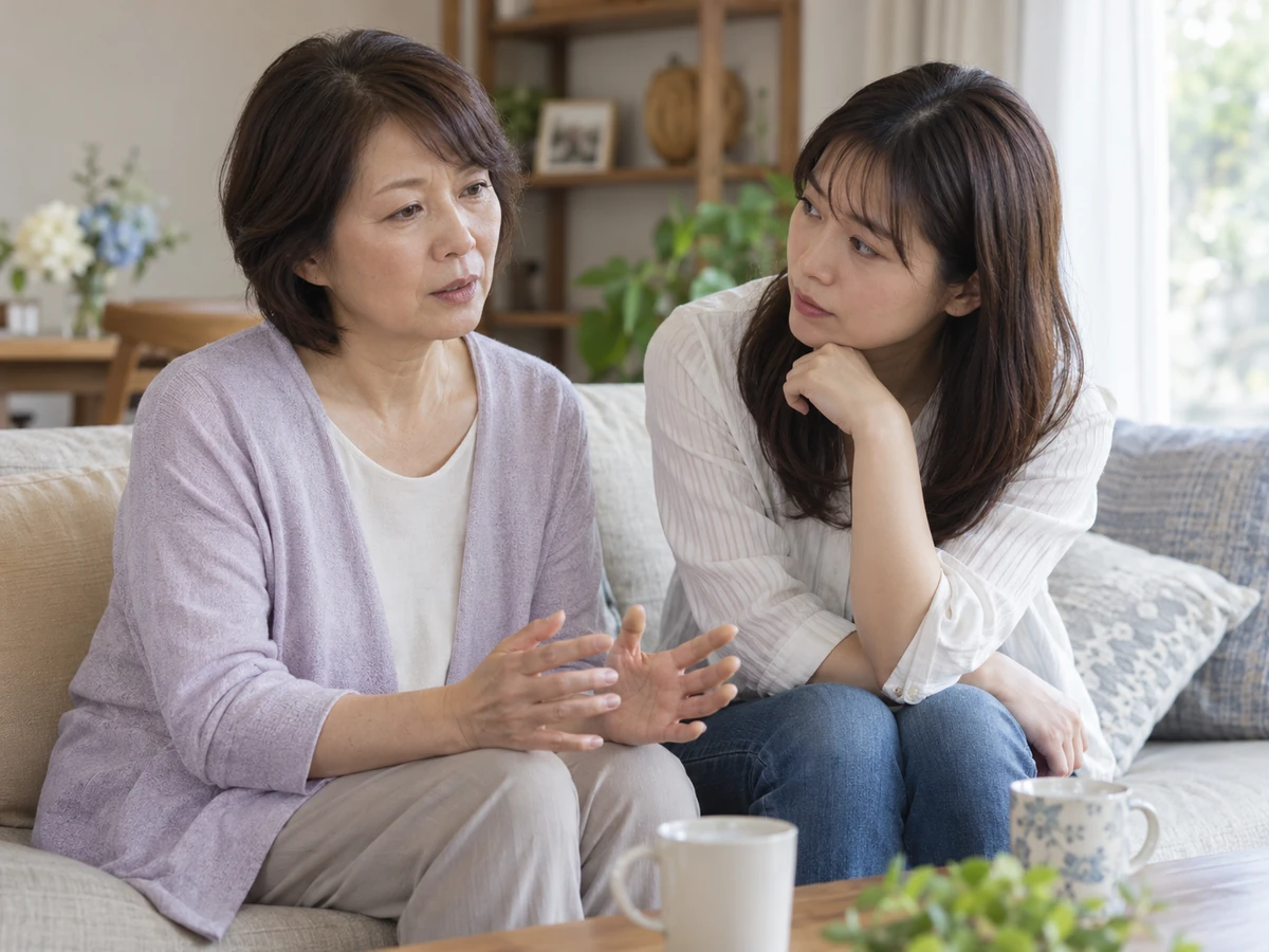 自宅のソファで向かい合い、女性の話に耳を傾ける家族の写真